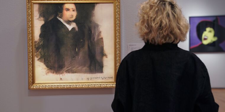 Une femme regarde une œuvre d'art créée par un algorithme par le collectif français nommé OBVIOUS, qui produit de l'art en utilisant l'intelligence artificielle, intitulée Portrait d'Edmond de Belamy chez Christie's à New York le 22 octobre 2018. L'œuvre a été vendue pour 432 500 dollars