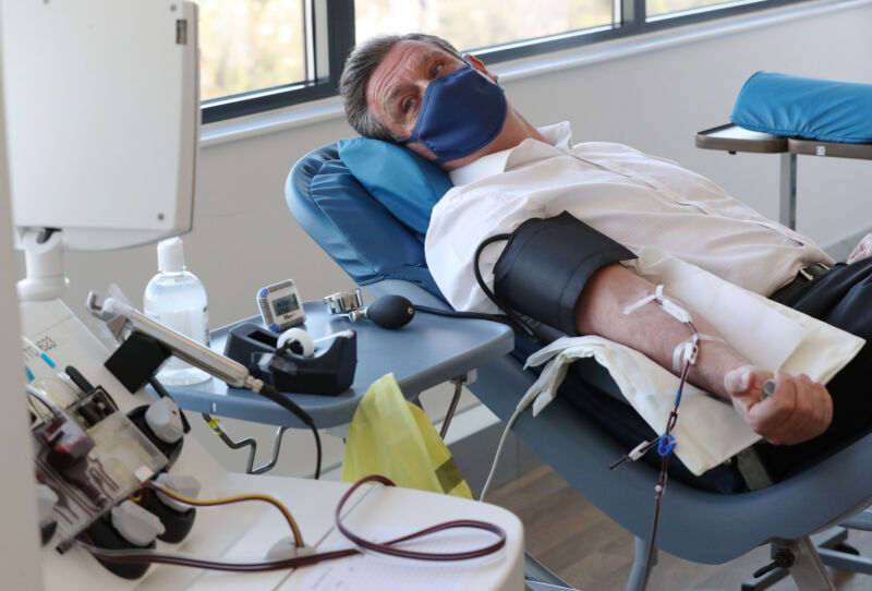 Seorang donor plasma terhubung ke mesin apheresis, yang memisahkan plasma dari darah saat orang-orang mendonorkan plasma darah untuk obat-obatan, di Twickenham Donor Centre, London barat daya pada 7 April 2021. 