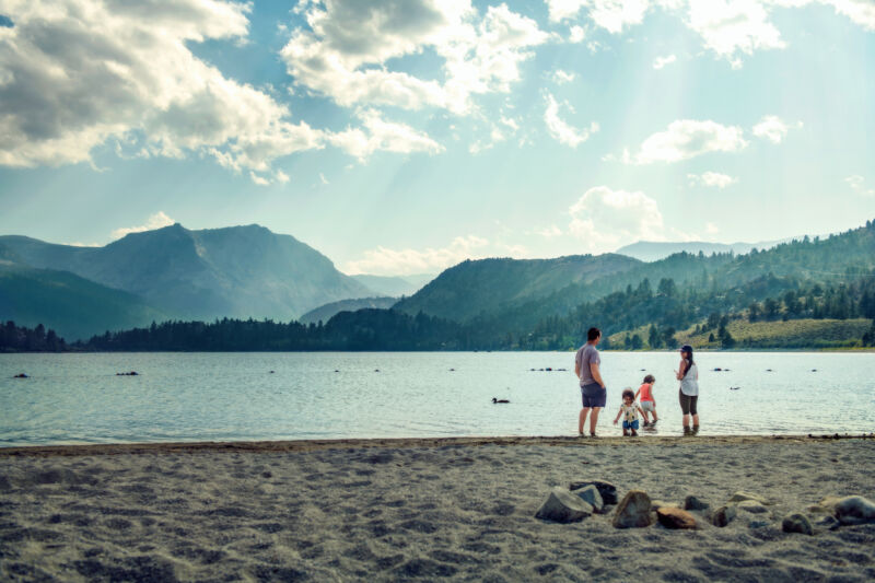 Image of people standing in front of a mountain lake.