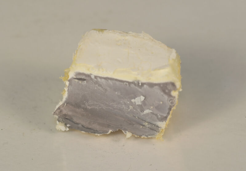 Technology Image of a chunk of metal surrounded by a whitish crust.