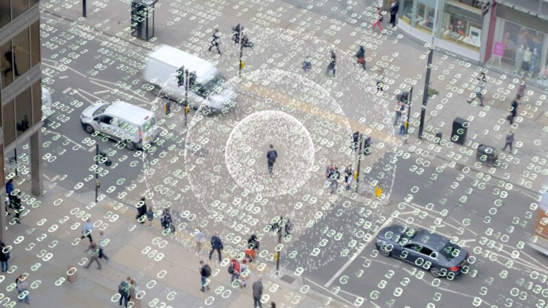 Visualization of a radio signal coming from a mobile phone used by a person walking through a crowded outdoor area.