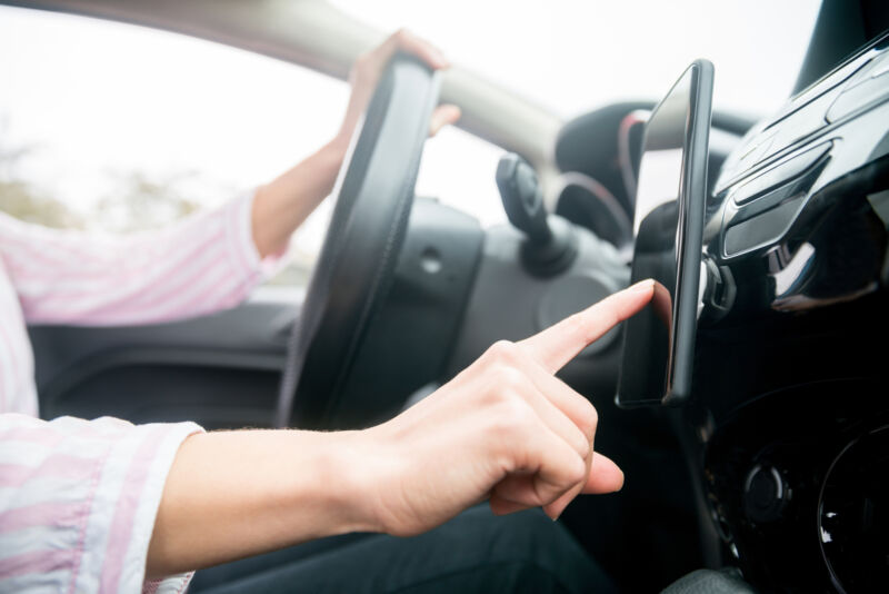 Close-up on a woman using GPS on her cell phone while driving her car