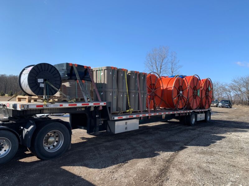 Giant rolls of fiber conduit and other equipment on a truck.