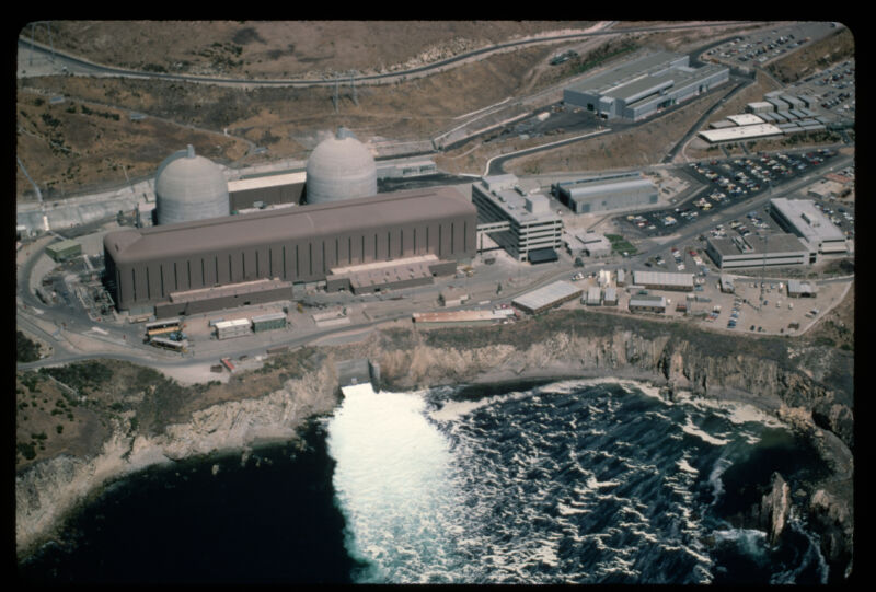 Image of two domed structures behind a large building on the coast.