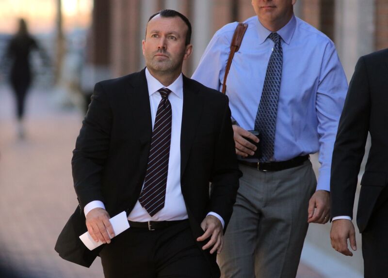 Former eBay executive James Baugh, wearing a suit, walks to court for his sentencing.