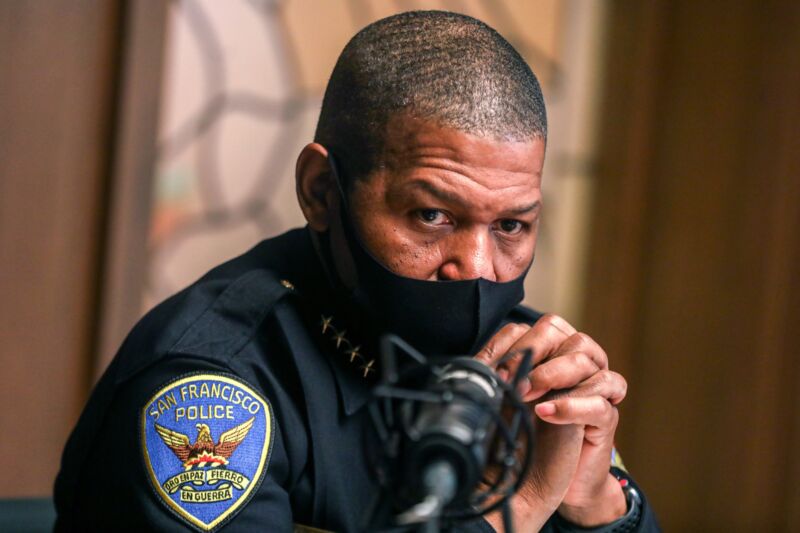 San Francisco Police Chief Bill Scott wearing a mask and sitting at a table.