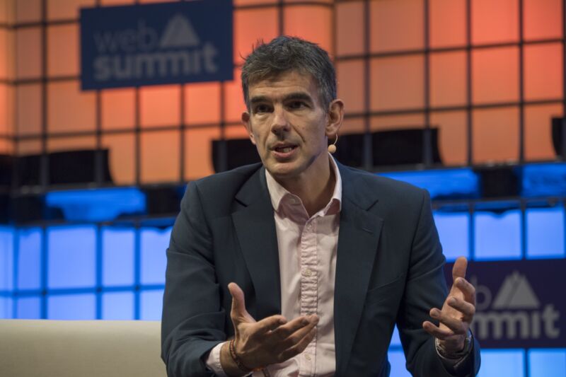 Google executive Matt Brittin speaking on stage at a conference and gesturing with his hands.