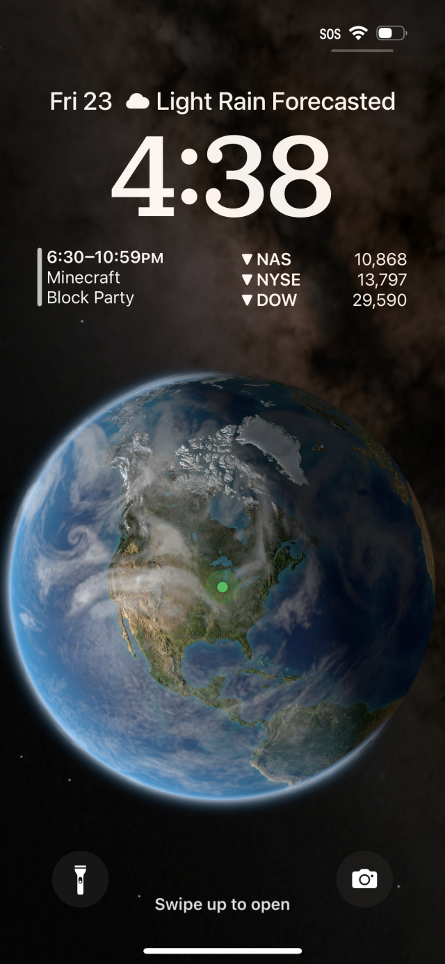 A wallpaper of a globe of the Earth in space with live cloud data and a green marker for the user's location
