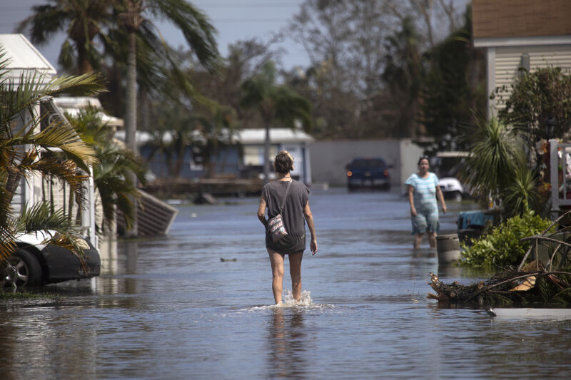 A resident of Gulf Air mobile home park walks through floodwaters from Hurricane Ian through her neighborhood near Fort Myers Beach on September 29.