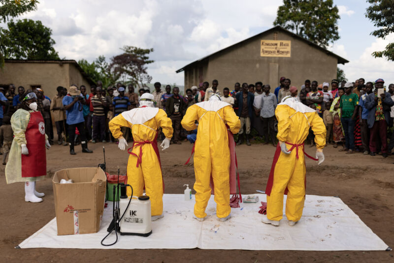 Red Cross workers don PPE prior to burying a 3-year-old boy suspected of dying from Ebola in 2022 in Mubende, Uganda.