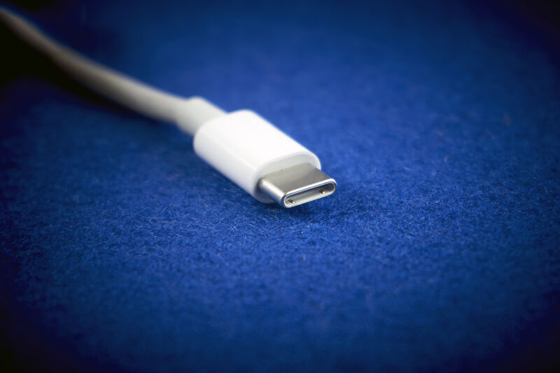 Close-Up of white USB Type-C cable on blue background.