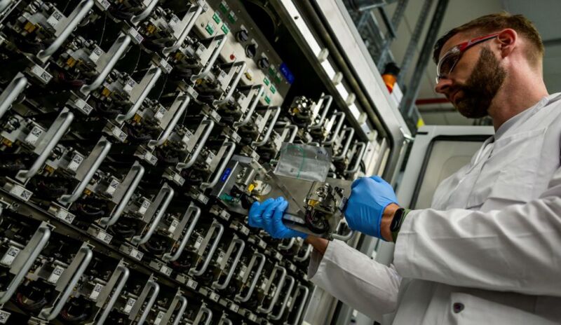 A technician removes a battery cell from a testing vault at the "Volkswagen Group Center of Excellence" battery cell research center in Salzgitter, Germany, on May 18, 2022.