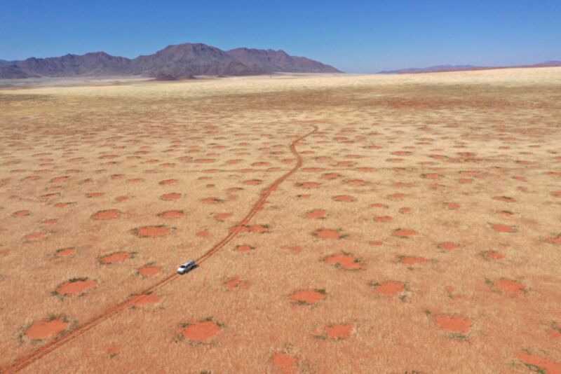 Снимок с дрона: автомобиль проезжает по природному заповеднику Намиб-Ранд, одному из сказочных кругов Намибии.