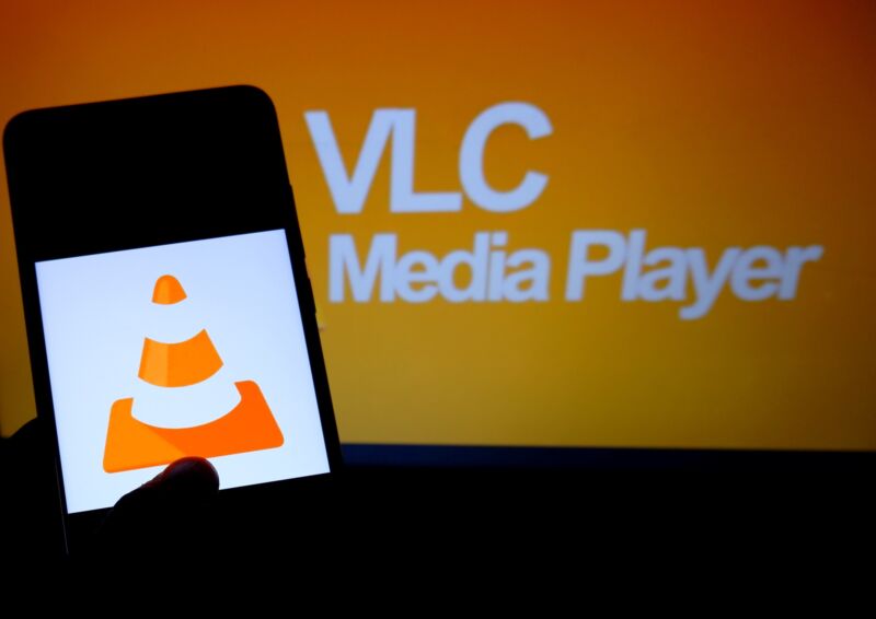 L'icône VLC, un cône de signalisation, s'affiche sur l'écran d'un smartphone avec les mots 