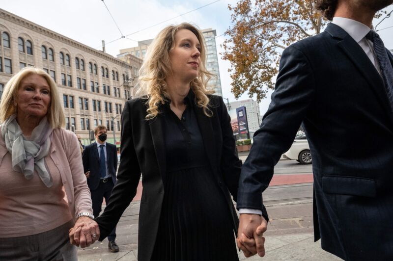 Elisabeth Holmes (C), founder and former CEO of blood testing and life sciences company Theranos, walks with her mother Noel Holmes and partner Billy Evans through the federal courthouse for her sentencing hearing on November 18, 2022 in San Jose, Calif..