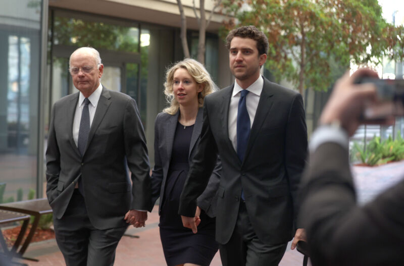 Former Theranos CEO Elizabeth Holmes (center) arrives at federal court with her father, Christian Holmes, and partner, Billy Evans, on October 17 in San Jose, California. Holmes appeared in federal court related to an attempt to overturn her fraud conviction.