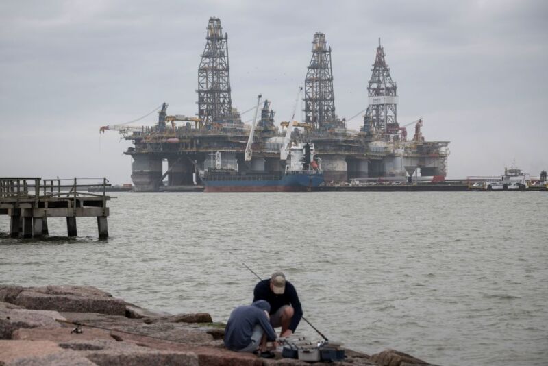 People fish in front of defunct oil drilling rigs in the Corpus Christi Ship Channel at Aransas Pass on March 11, 2019, in Port Aransas, Texas.