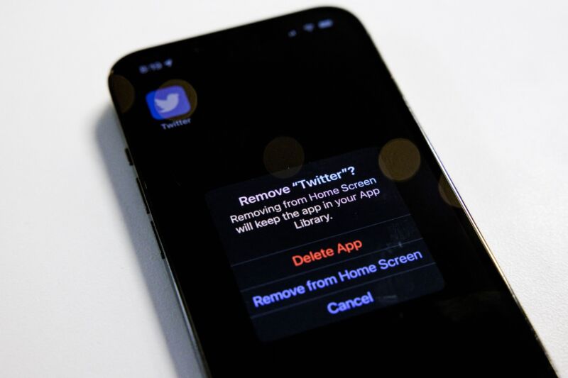 An iPhone screen prompt asks a user to confirm if they want to remove the Twitter app from the device.