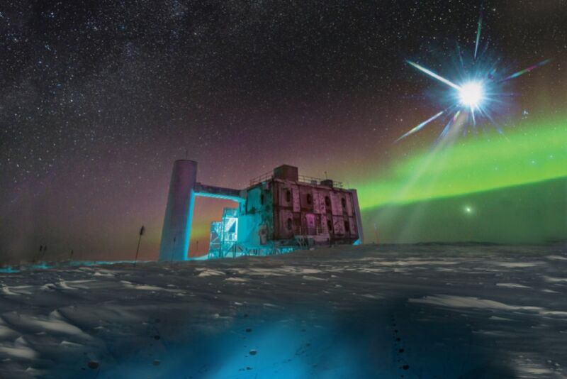 Représentation artistique d'une source cosmique de neutrinos brillant au-dessus de l'observatoire IceCube en Antarctique.  Sous la glace se trouvent des détecteurs optiques qui captent des signaux de neutrinos.