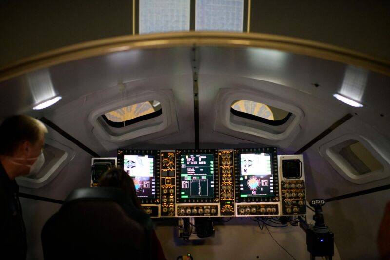 People look inside an Orion spacecraft simulator, which is used to train for docking to the Gateway space station, at the Johnson Space Center's System Engineering Simulator facility in Houston.