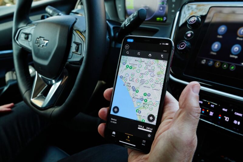 Someone looks at a smartphone app showing charging stations in the Los Angeles area.