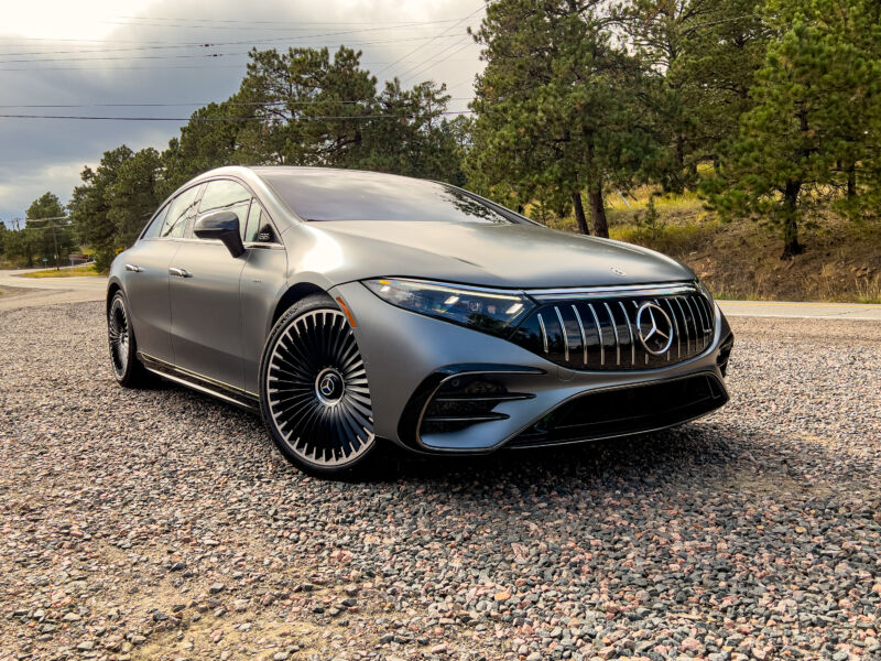 A mercedes-AMG EQS sedan near some pine trees