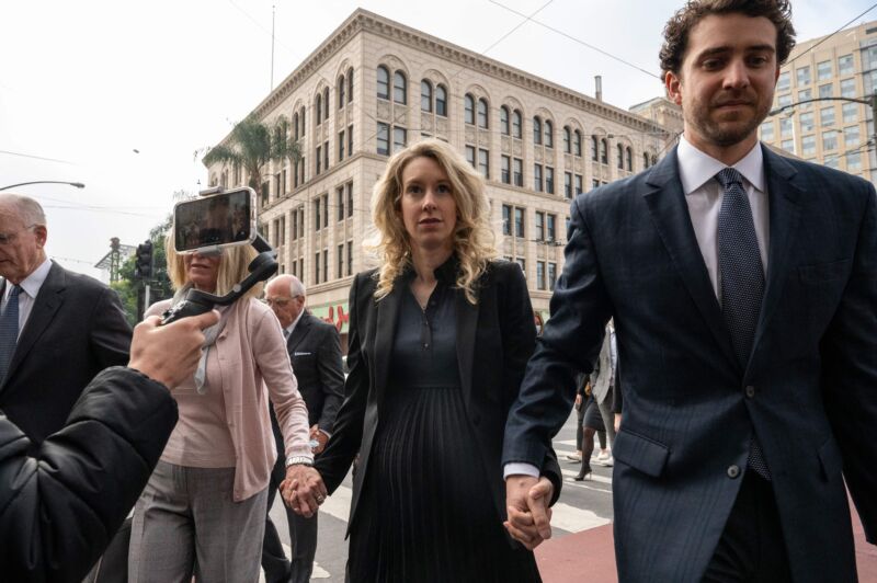 Elizabeth Holmes (C), founder and former CEO of blood-testing and life sciences company Theranos, walks with her mother Noel Holmes and partner Billy Evans into the federal courthouse for her sentencing hearing on November 18, 2022, in San Jose, California. 