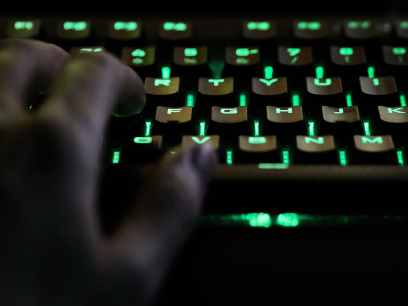 Man's hand using rgb keyboard while live streaming
