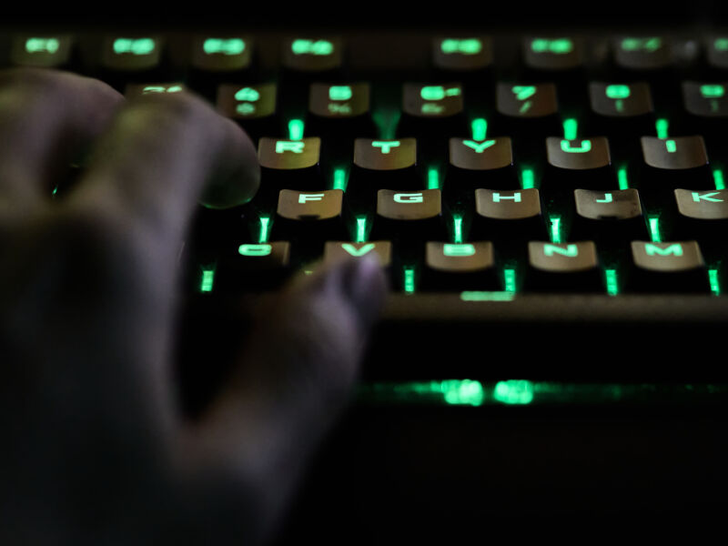 La mano de un hombre usando un teclado RGB durante una transmisión en vivo