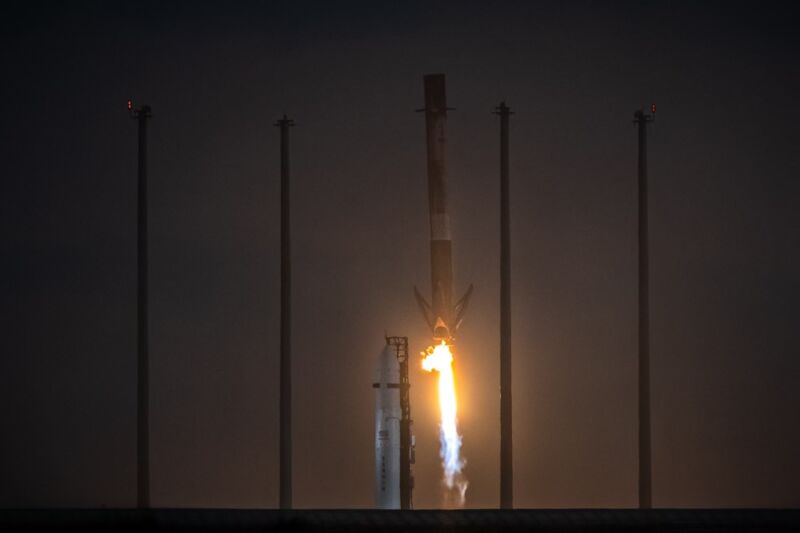 A Falcon 9 rocket lands Thursday evening after launching the OneWeb 1 mission. Relativity Space's Terran 1 rocket is in the background, awaiting its debut launch.