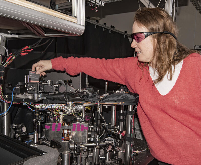 Image of a researcher leaning over a large, complicated laser device.