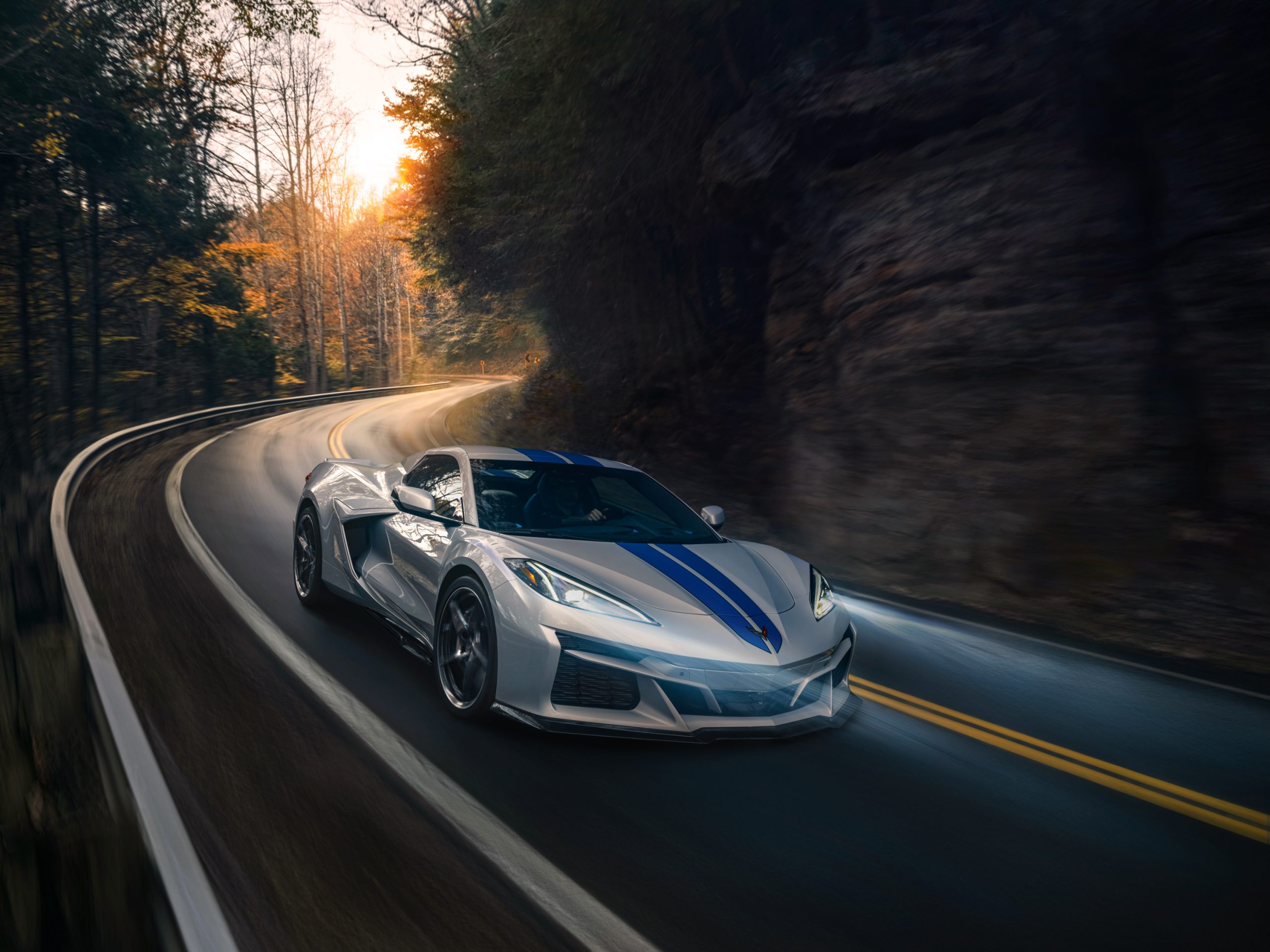 A silver and blue Corvette E-Ray on the road