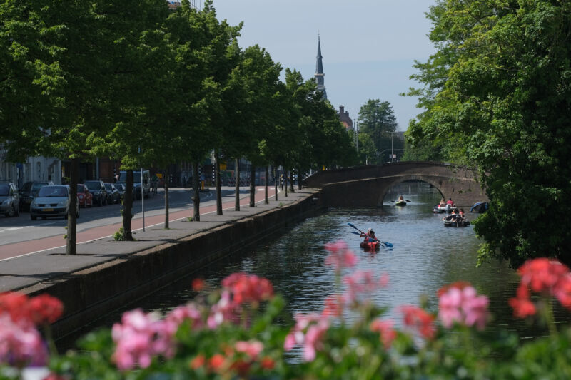 People kayaking and riding boats along a canal in The Hague, Netherlands.