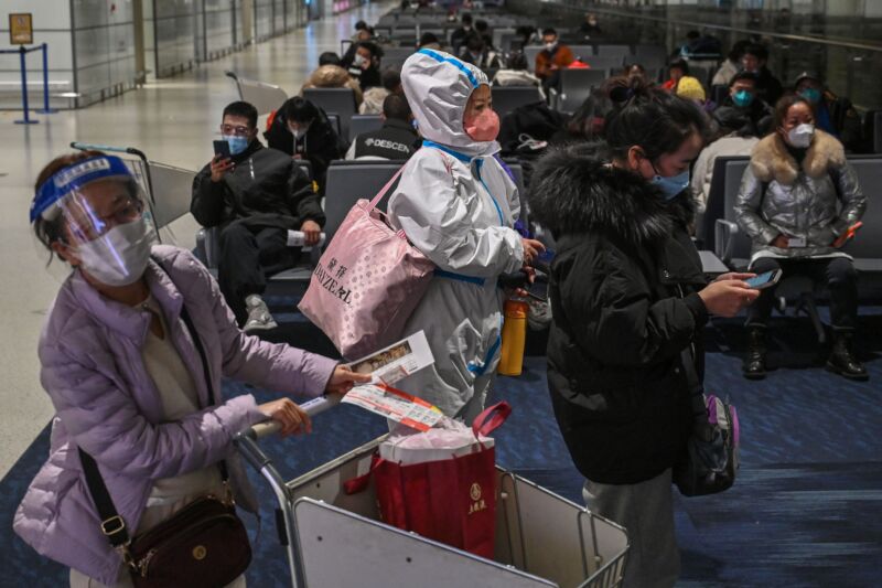 A passenger wearing protective clothing amid the COVID-19 pandemic waits to board a domestic flight at Shanghai Pudong International Airport on January 3.