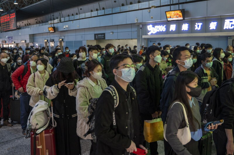 Passengers wearing face masks wait to board a high-speed railway train in Guangzhou South railway station on January 15, 2023, in Guangzhou, China. China is currently experiencing Spring Festival travel season, where millions of Chinese travel around the country before celebrating the Chinese or Lunar New Year. 