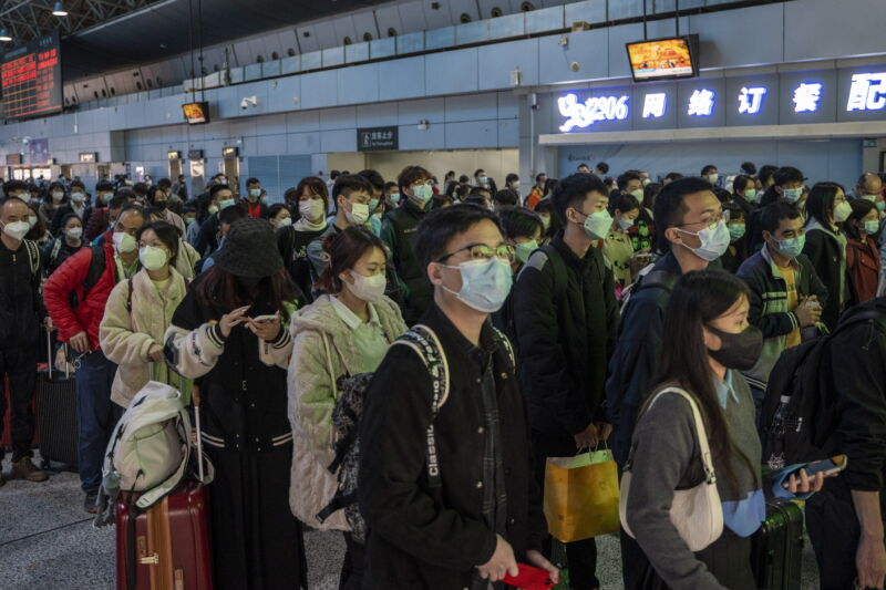 Passengers wearing face masks wait to board a high-speed railway train in Guangzhou South railway station on January 15, 2023, in Guangzhou, China. China is currently experiencing Spring Festival travel season, where millions of Chinese travel around the country before celebrating the Chinese or Lunar New Year.