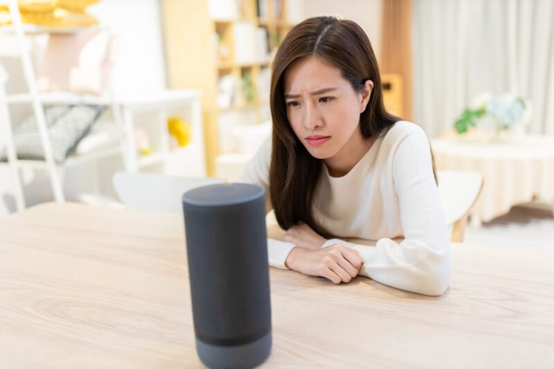 Woman looking puzzled at a smart speaker