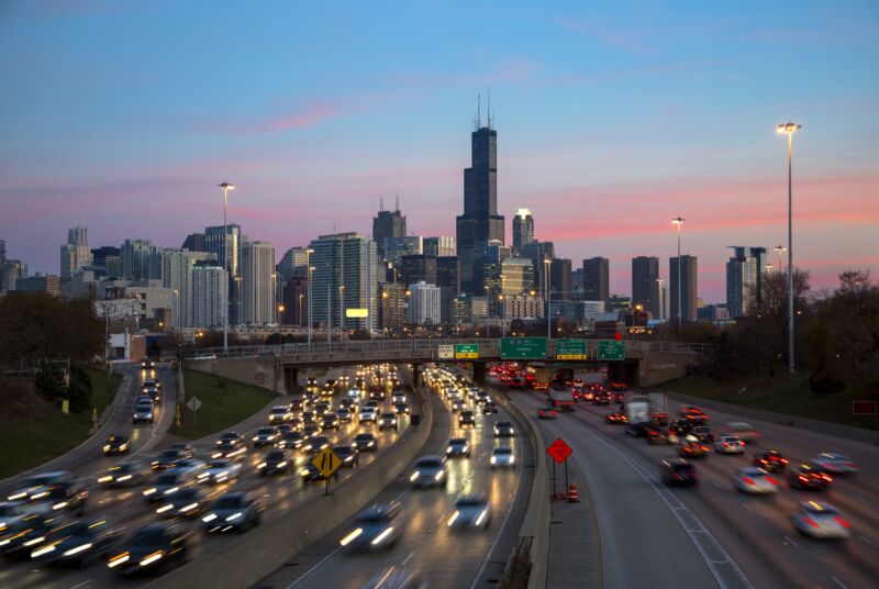 Traffic on the Kennedy Expressway in Chicago at dusk, with the downtown skyline behind.