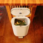 Image of a white plastic trash can with the lid open.