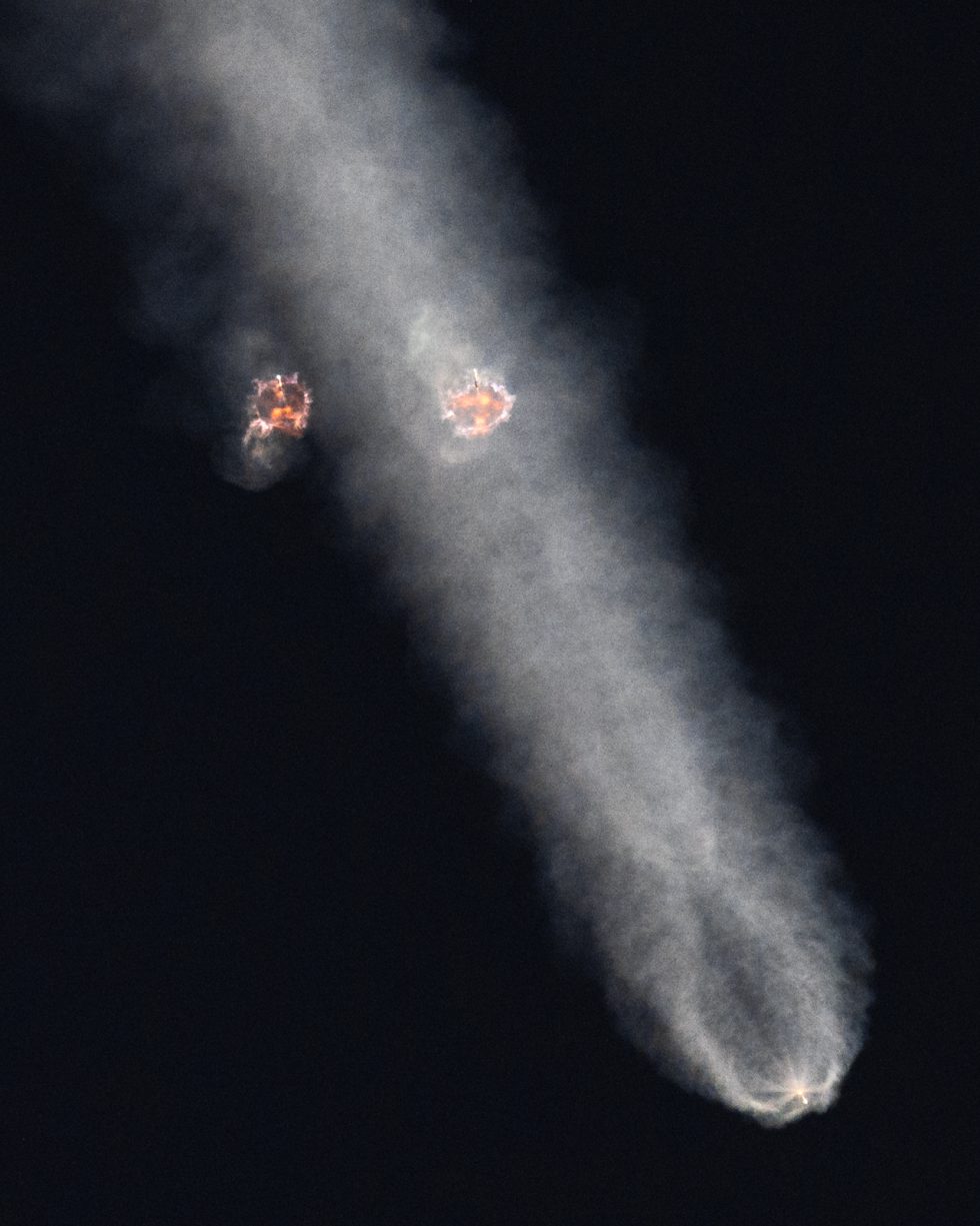 The Falcon Heavy's side-mounted boosters perform a boost-back burn while the center core continues powering its way to space.