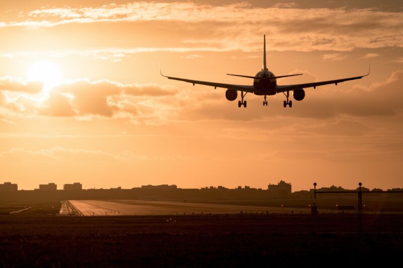 An airplane landing at sunset.