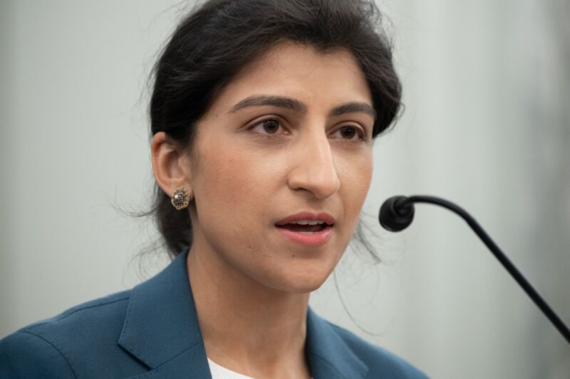 Lina Khan speaks into a microphone while answering questions at a Senate confirmation hearing.
