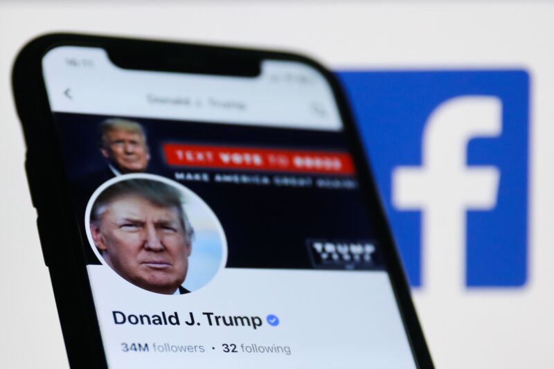 Photo illustration showing Donald Trump's Facebook profile on a phone screen. A Facebook logo is seen behind the phone.