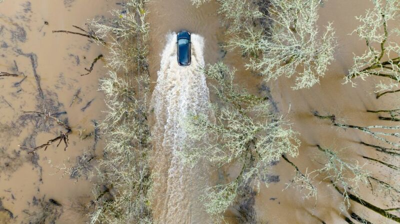 A vehicle drives on a flooded road in Sebastopol, California, on January 5, 2023.