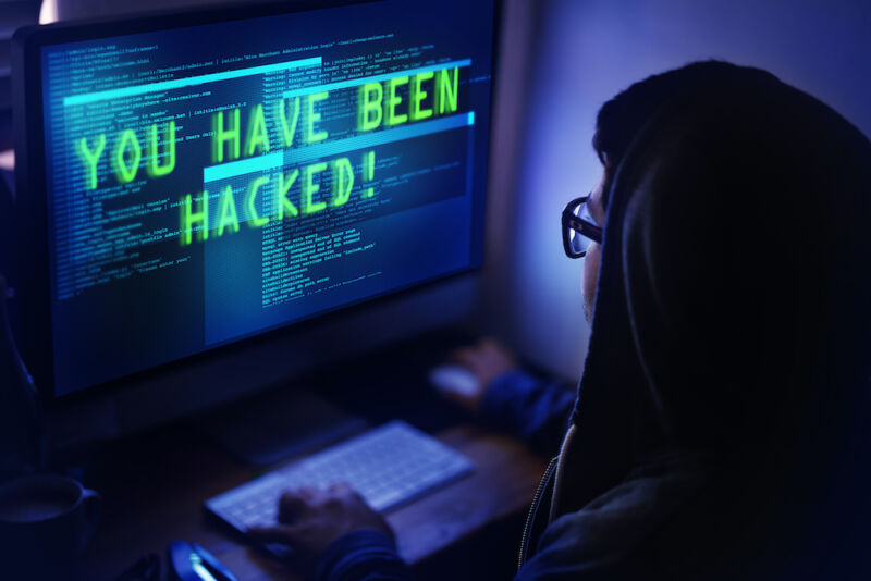 Shot of a person looking at a hacking message on her monitor reading