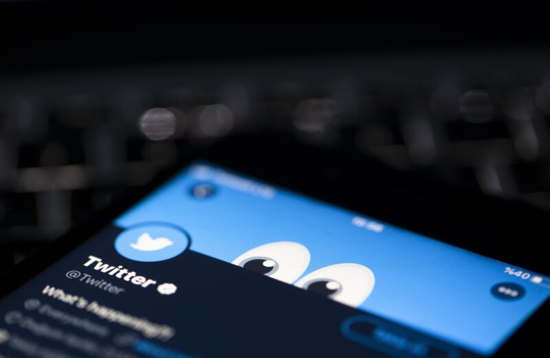 Twitter application's logo is seen on a screen of a mobile phone