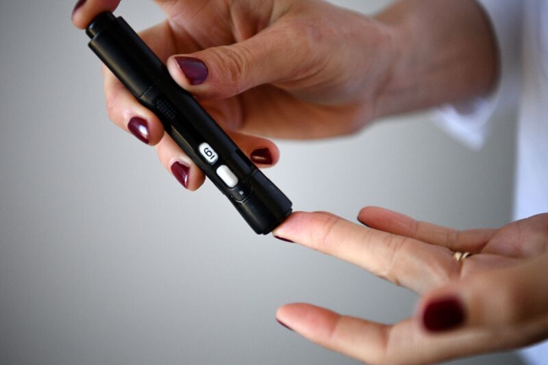 A woman with diabetes pricks her finger to take a blood sample to measure the glycemia in Paris on March 24, 2020.