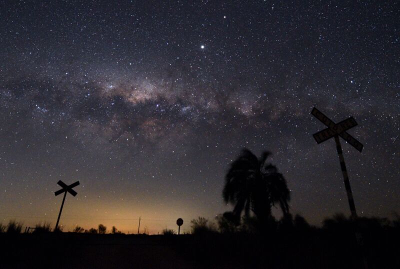 Milky The galactic center of the Milky Way and Jupiter (brightest point at top center) are seen from the countryside