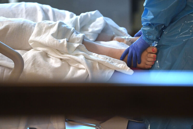 A critical care nurse assists a patient.