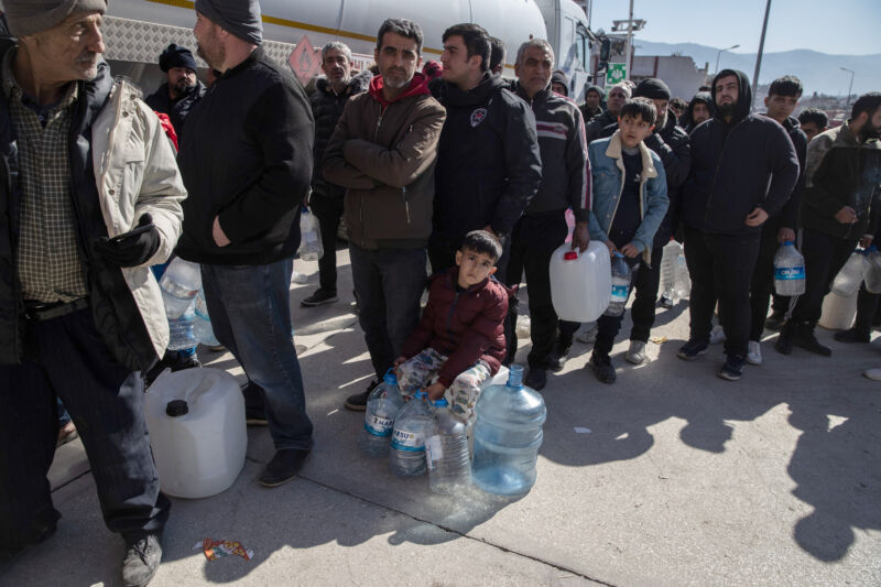 People queue for clean water on February 9, 2023, in Hatay, Turkey.